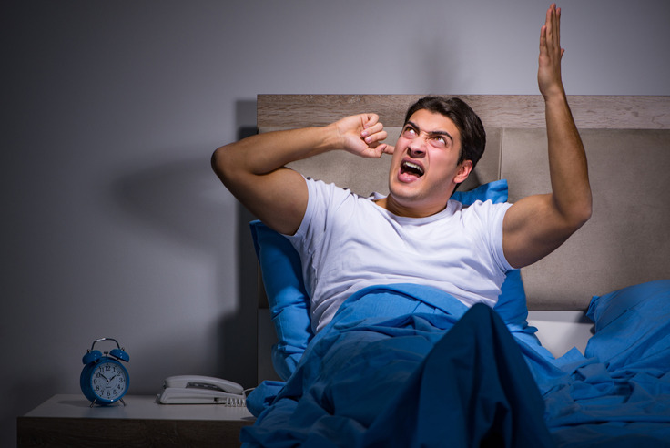 man cannot sleep because of noisy neighbour