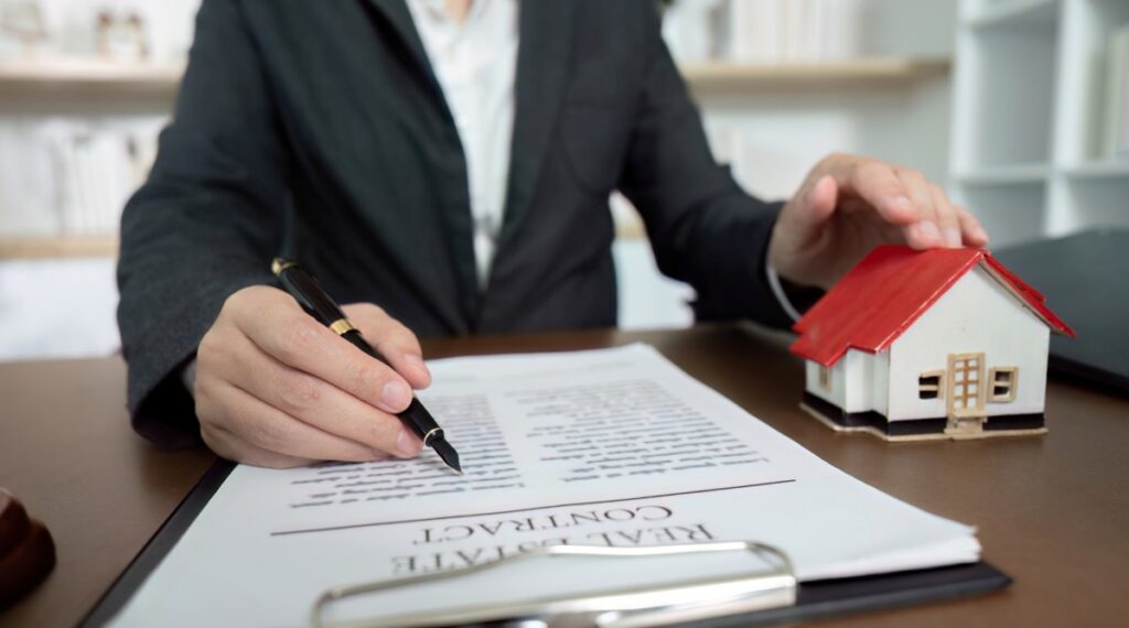 Lawyer signing real estate contract with miniature house model