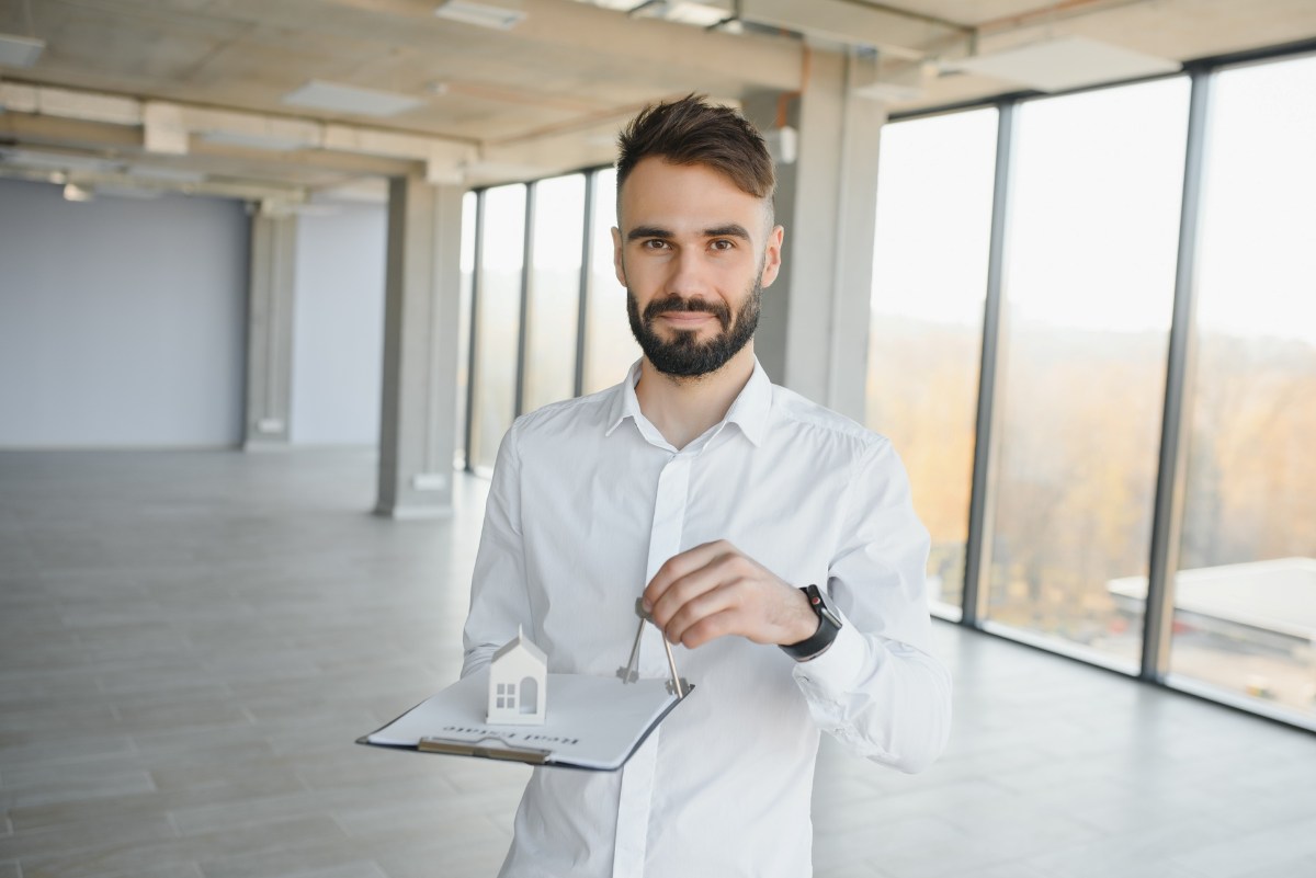 Male real estate agent with key in room