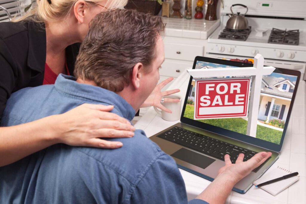 Couple In Kitchen Using Laptop to Research Real Estate