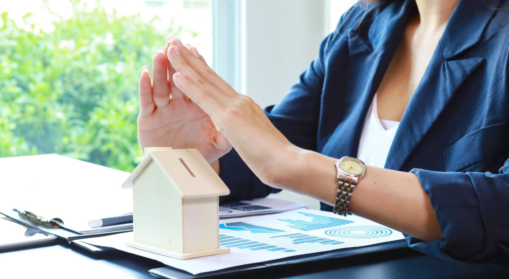Close-up of a woman holding a miniature house, representing home buying and property ownership