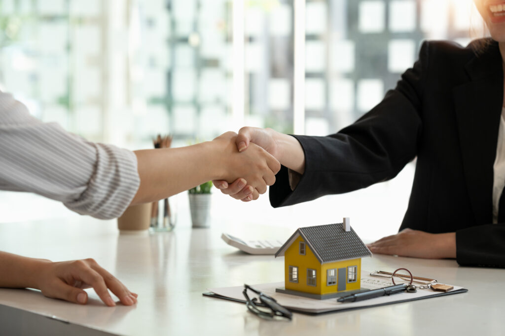 Real estate broker and customer shaking hands after signing a property agreement