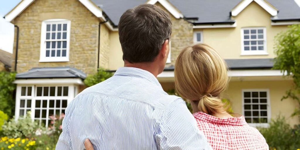 Man and woman standing in front of a house.