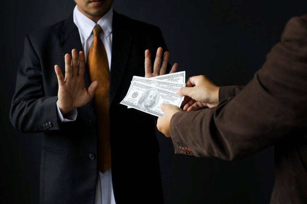 Businessman refusing a bribe, representing corruption and bribery.
