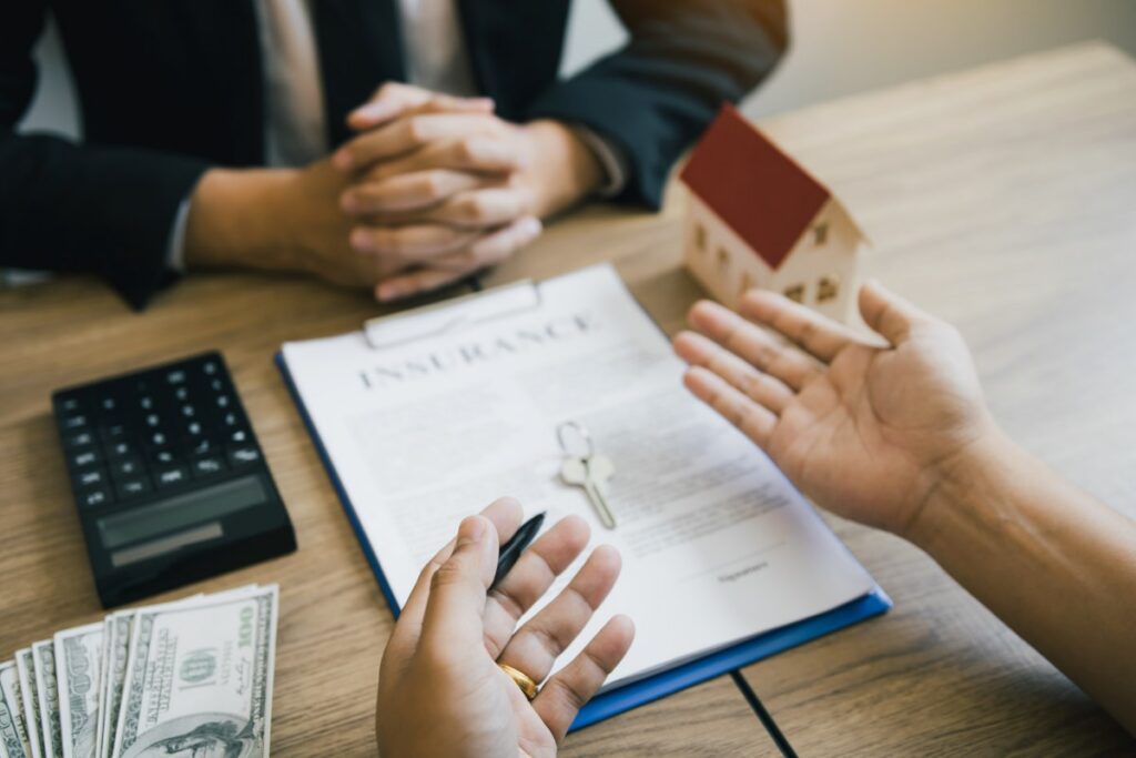 Customers negotiating the cost of a house with a real estate agent.