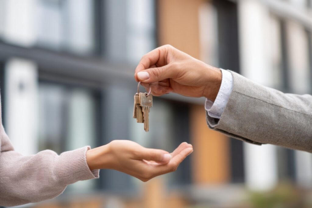 A person holds out keys while another person reaches to take them