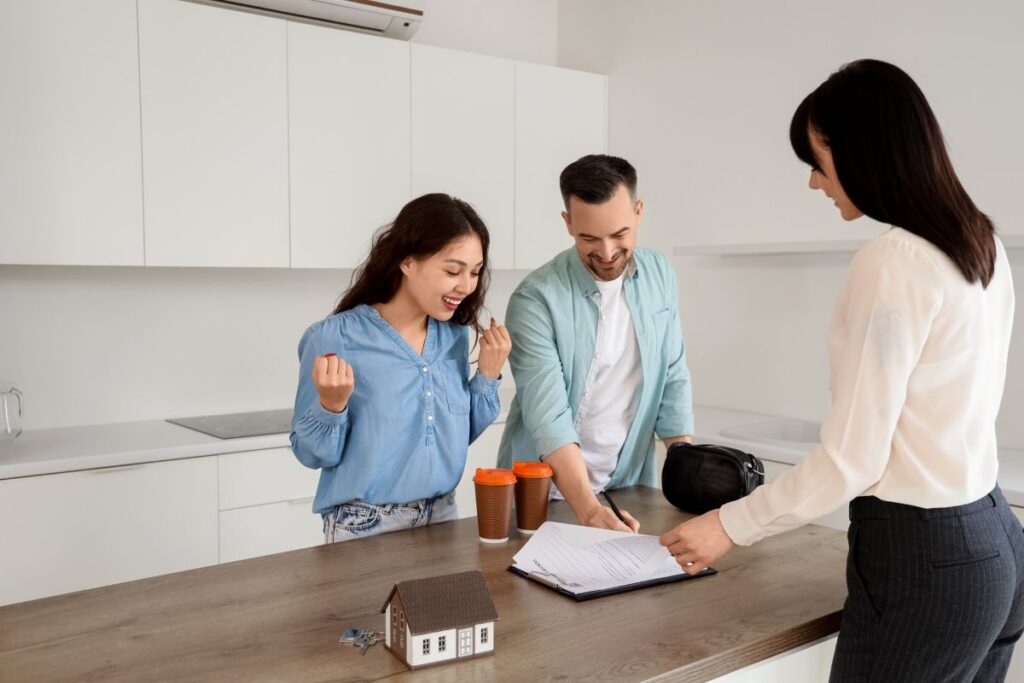 Female real estate agent selling house to couple in kitchen