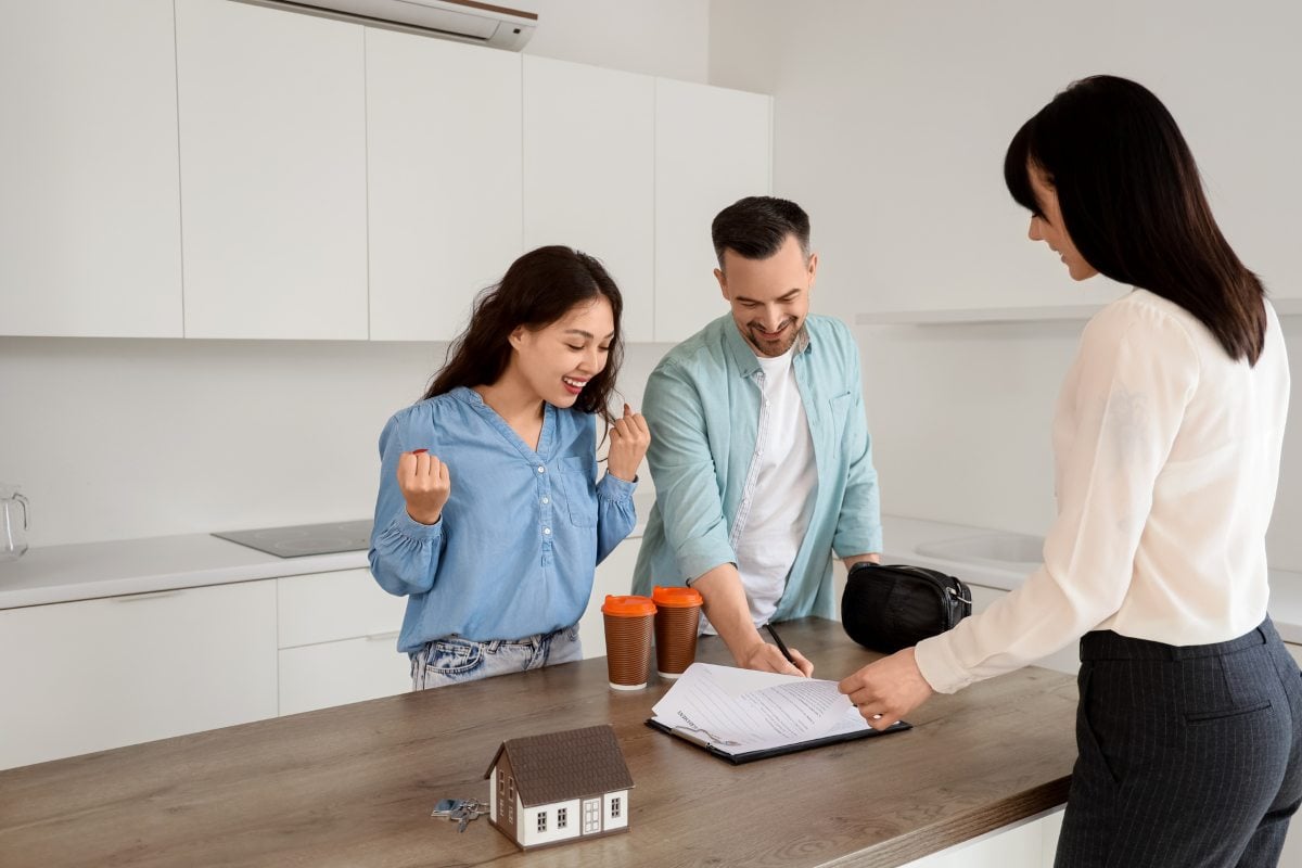 Female real estate agent selling house to couple in kitchen