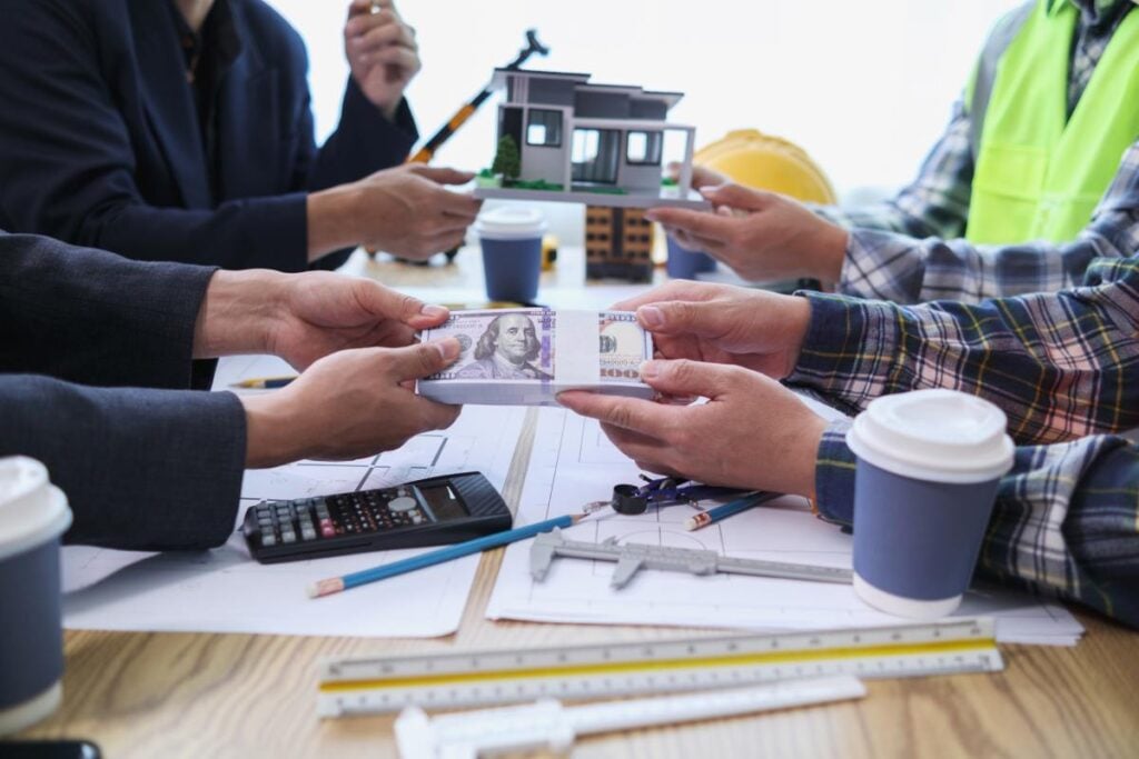 team of engineers and architects discuss house plan design and estimate construction prices to suit the construction budget