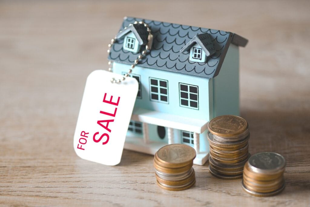 House for sale , coins stack and house model on sale with hang tag or real estate home and commercial building