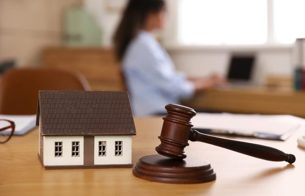 Judge s gavel with house model on lawyer s table in office