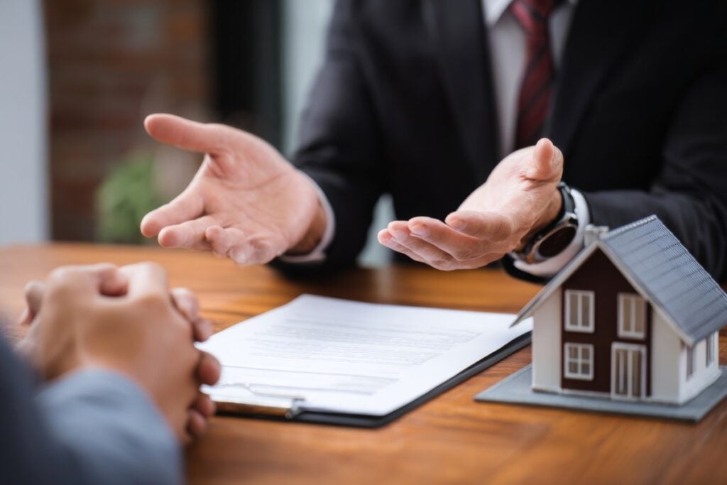 A professional real estate agent presents property information to a client